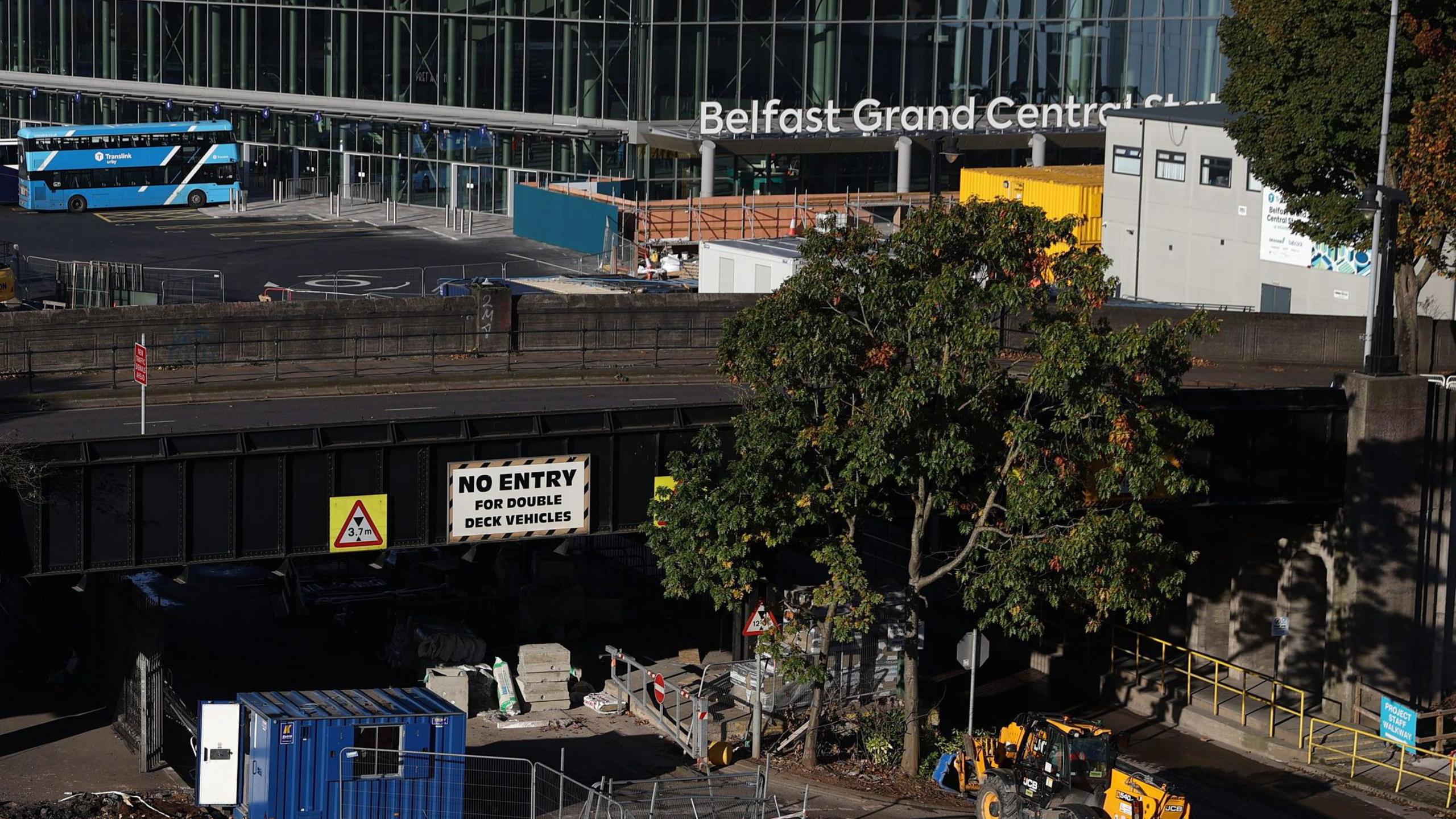 A birds eye view of the Grand Central Station. You can see a blue bus, construction machinery and a white sign which reads NO ENTRY. 