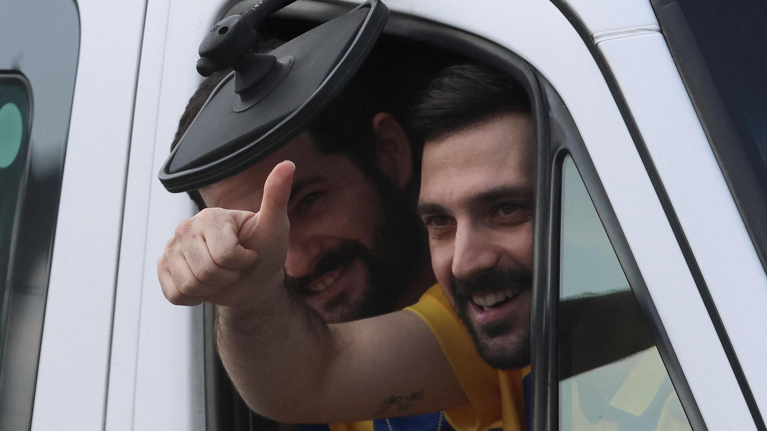 Brothers Gali Berman and Ziv Berman, released hostages wave outside the window of a car