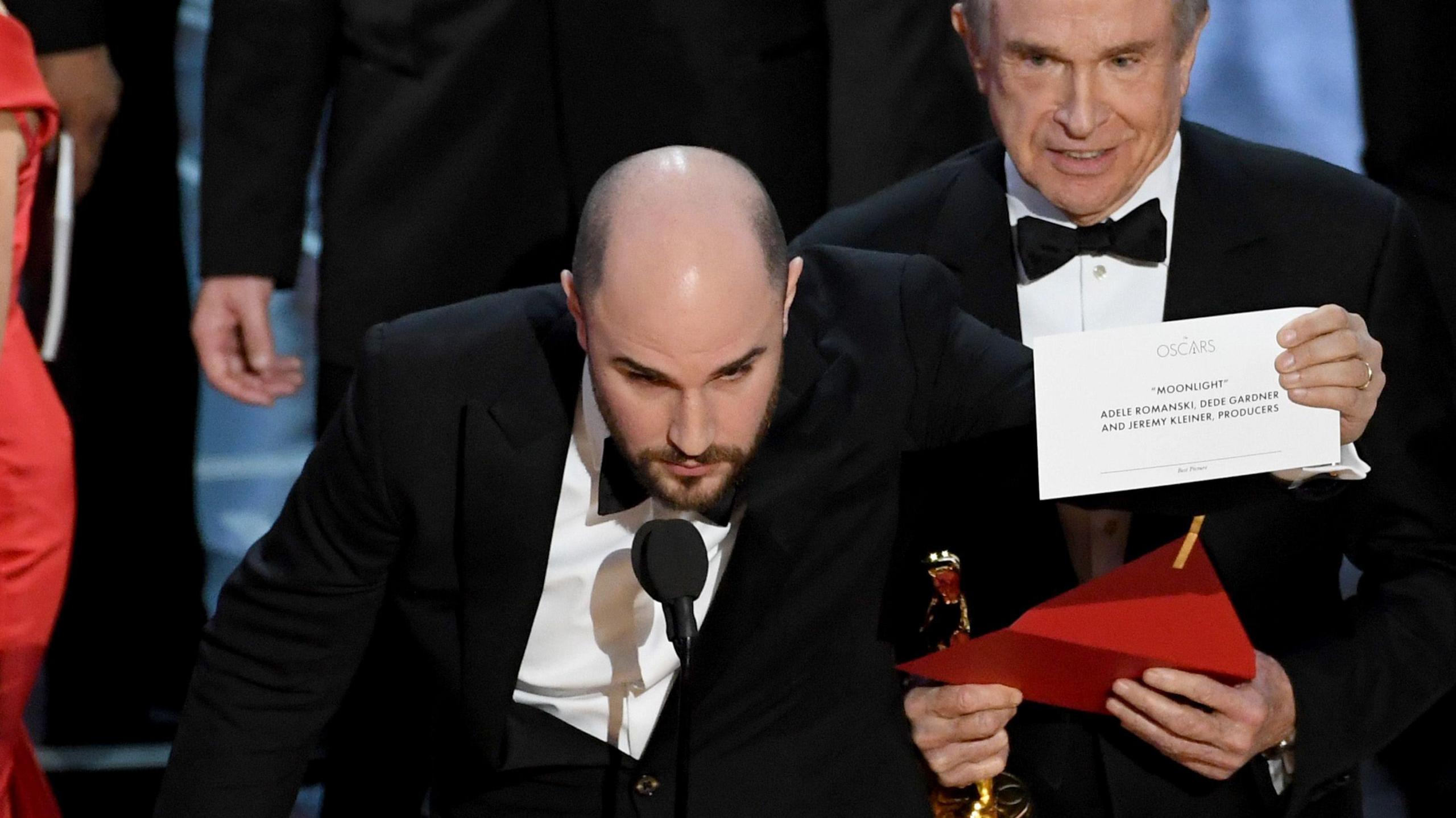 A person holds up a letter saying Moonlight on stage at the Oscars