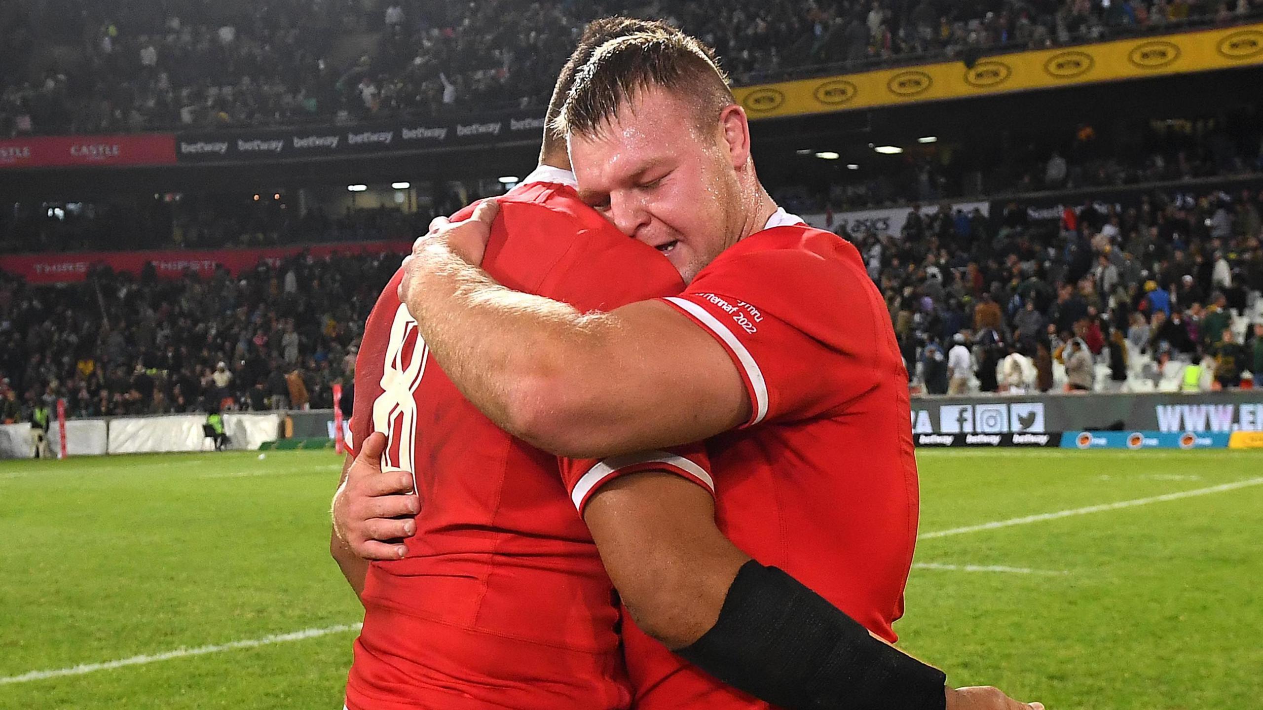 Dewi Lake a Taulupe Faletau yn cofleidio ar y cae yn Bloemfontein.