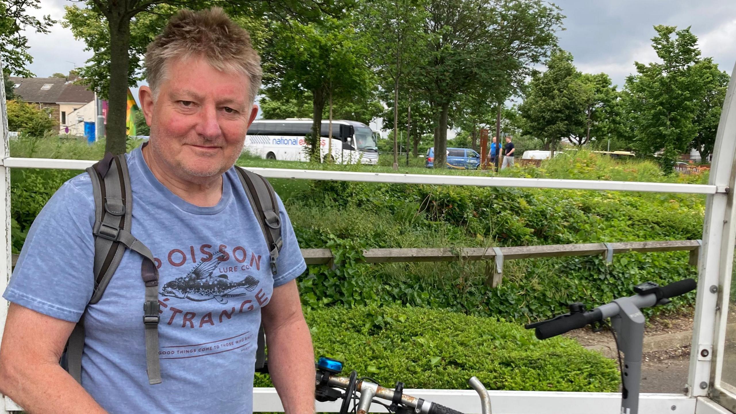 Dave Allett standing by his bicycle