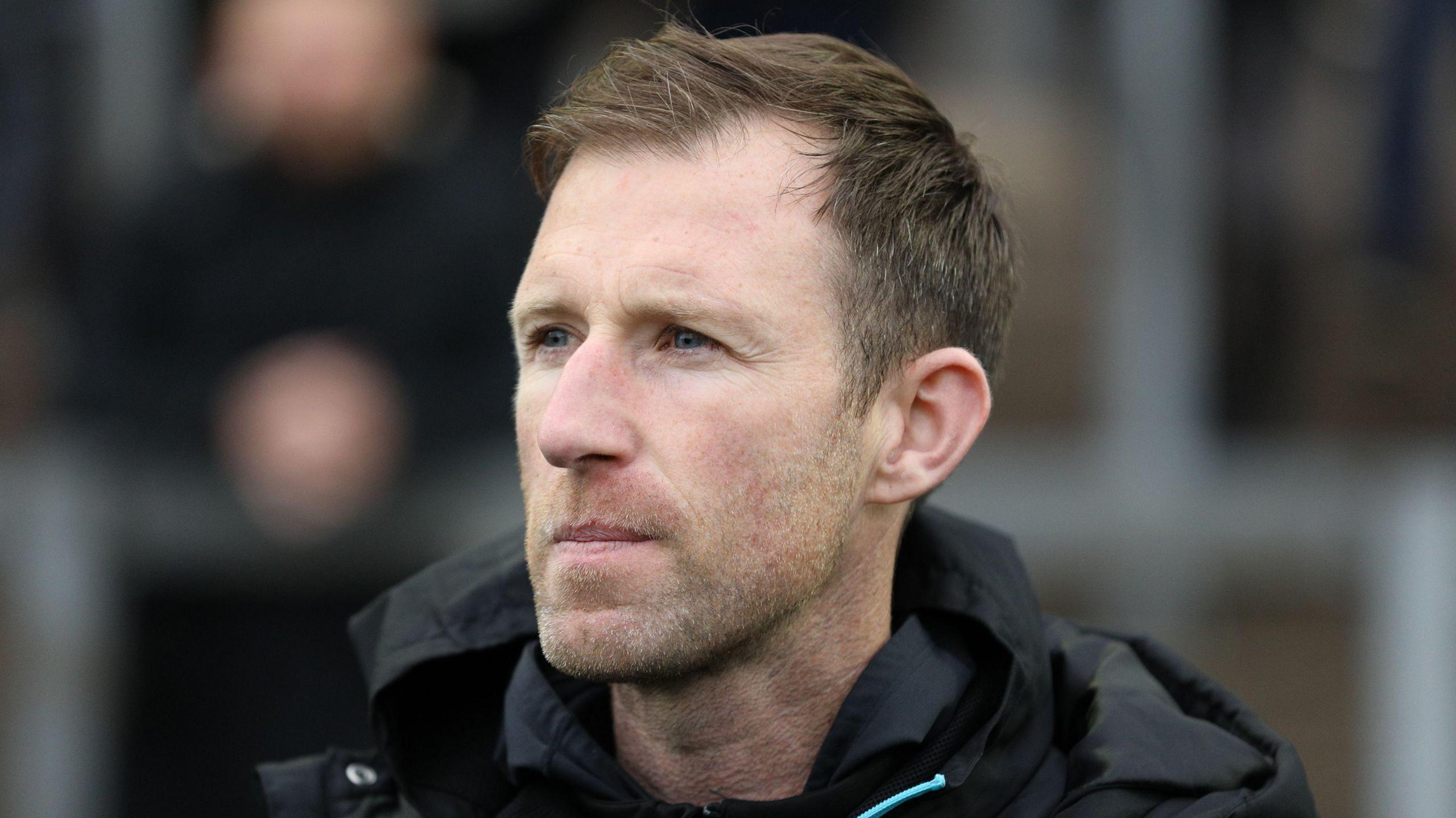 Carlisle head coach Mike Williamson watching his team from the touchline