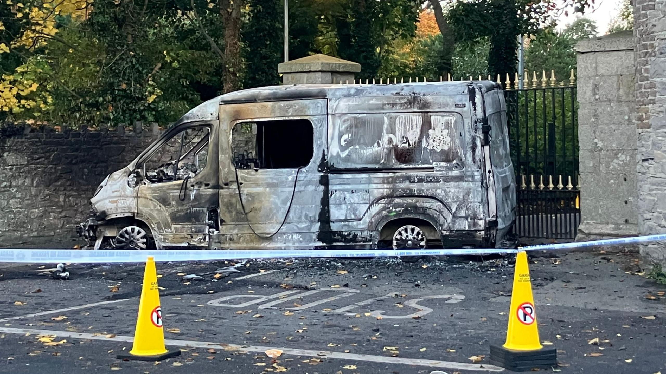 A burnt out garda van surrounded by a police cordon 