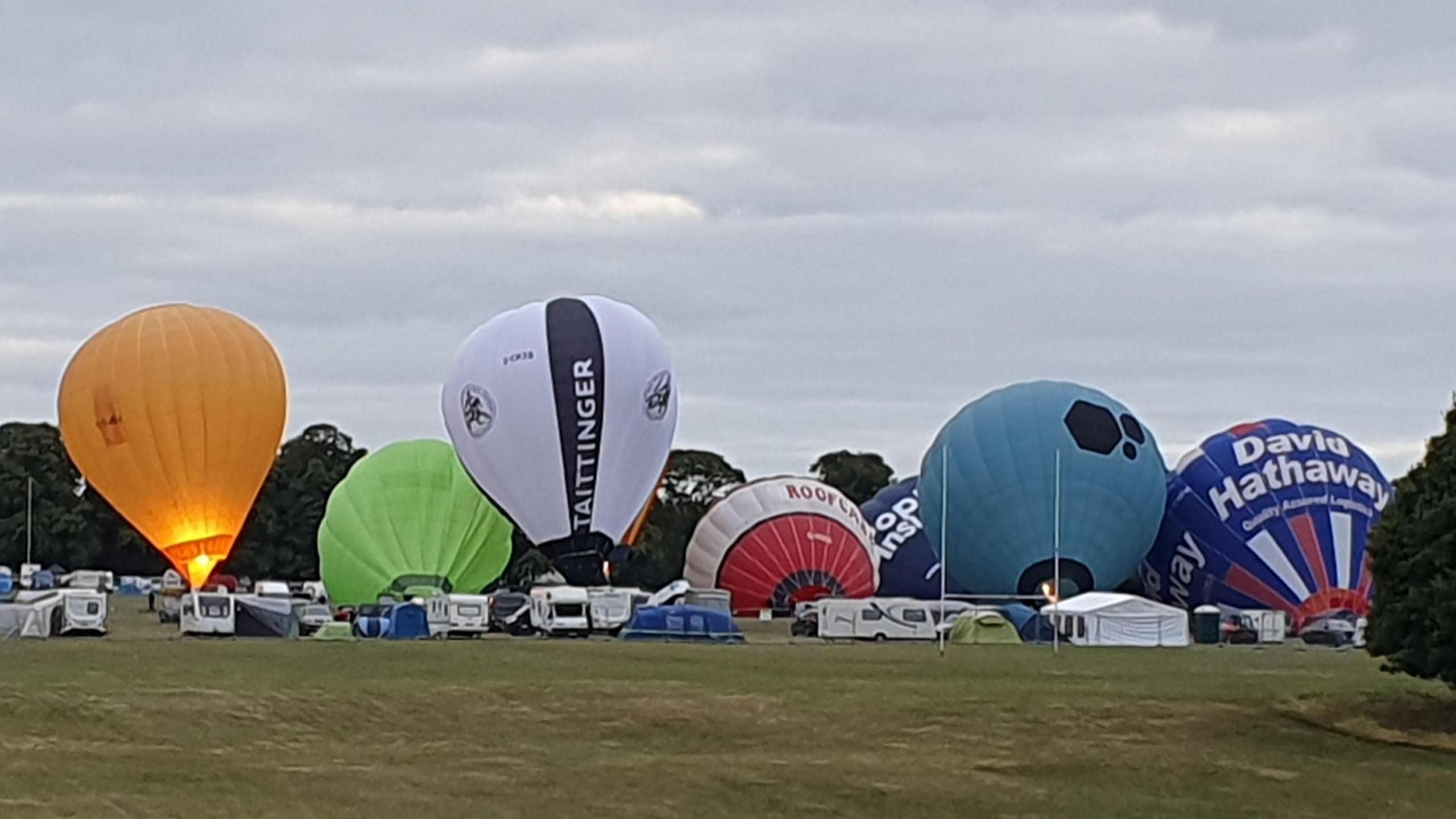 General view of hot air balloons inflating before flight at Northampton's Racecourse