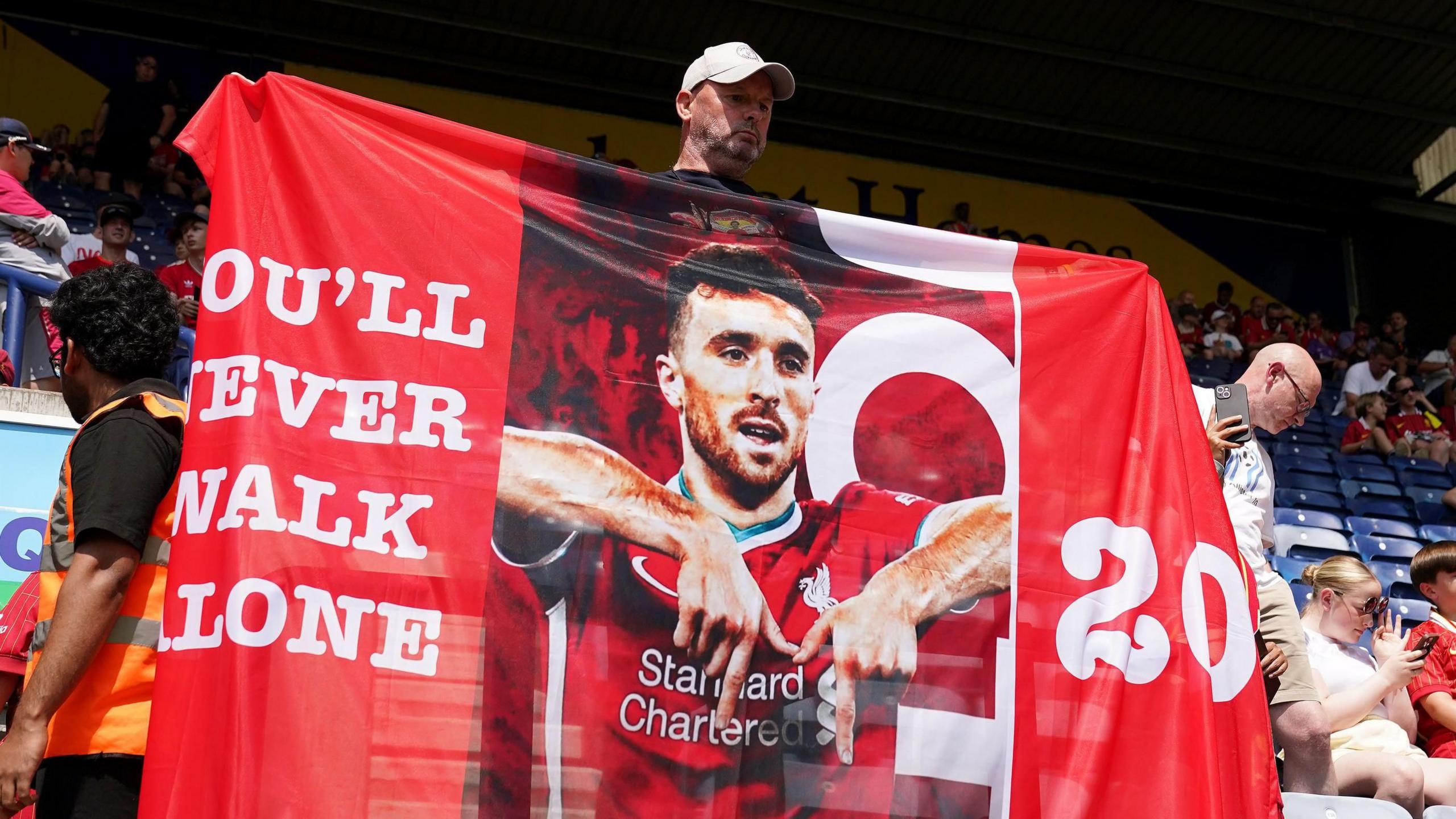 A Liverpool fan holding a banner in tribute of Liverpool player Diogo Jota ahead of the pre-season friendly match at Deepdale Stadium, Preston. Liverpool remain in mourning following the death of Portugal forward Jota, 28, and his brother Andre Silva, 25, in a car crash in Zamora, Spain, on 3 July