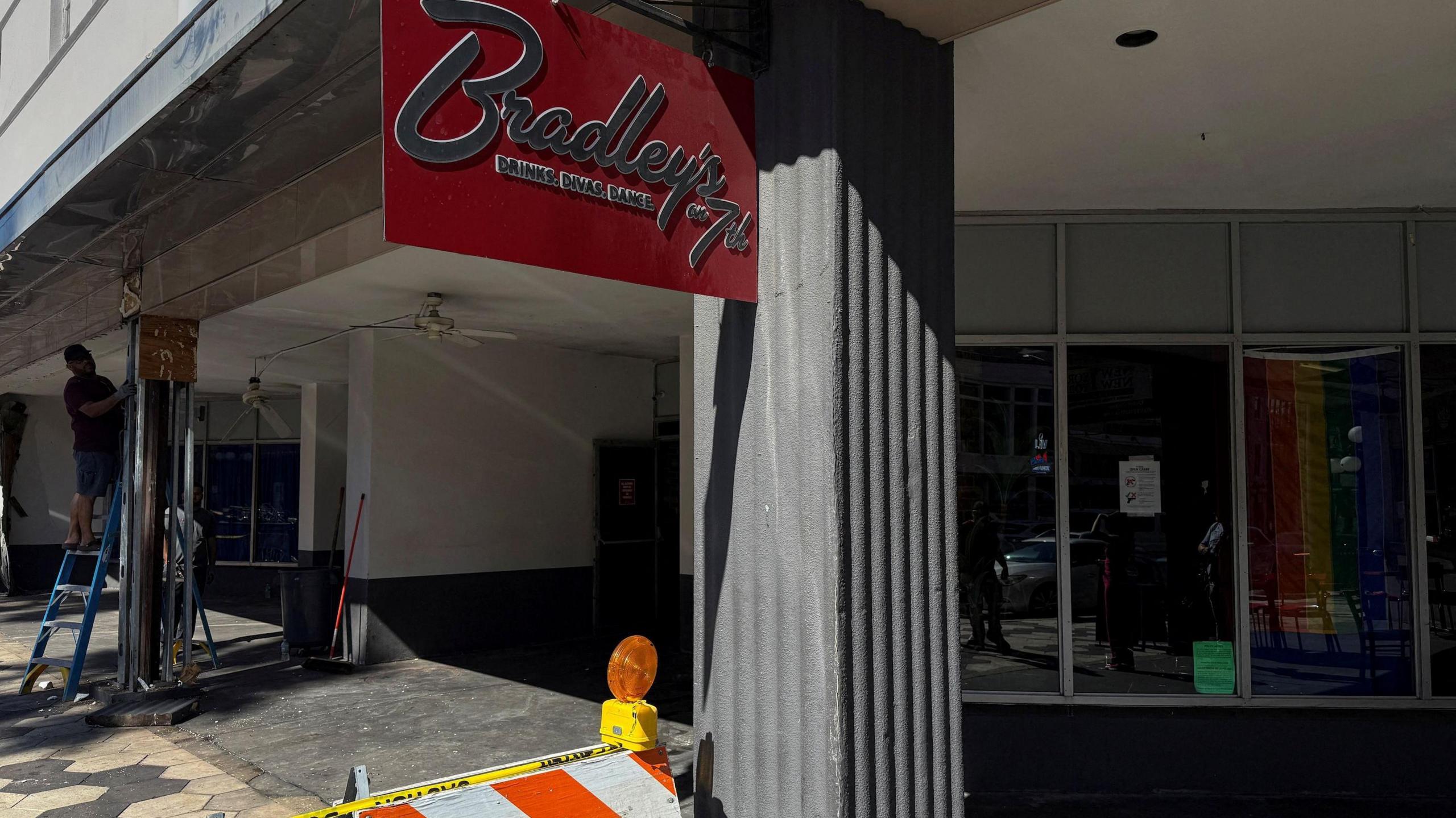 The empty front of the bar, with Bradley's sign hanging above and some police tape