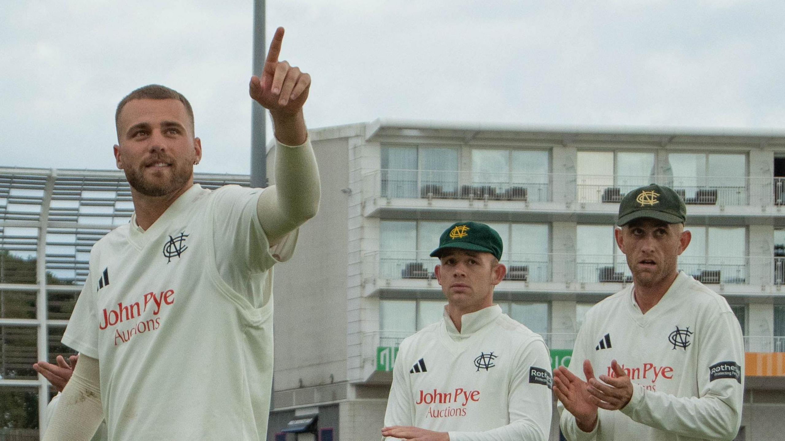 Fergus O'Neill points to someone in the crowd as he leaves the pitch with two team-mates behind him, both applauding