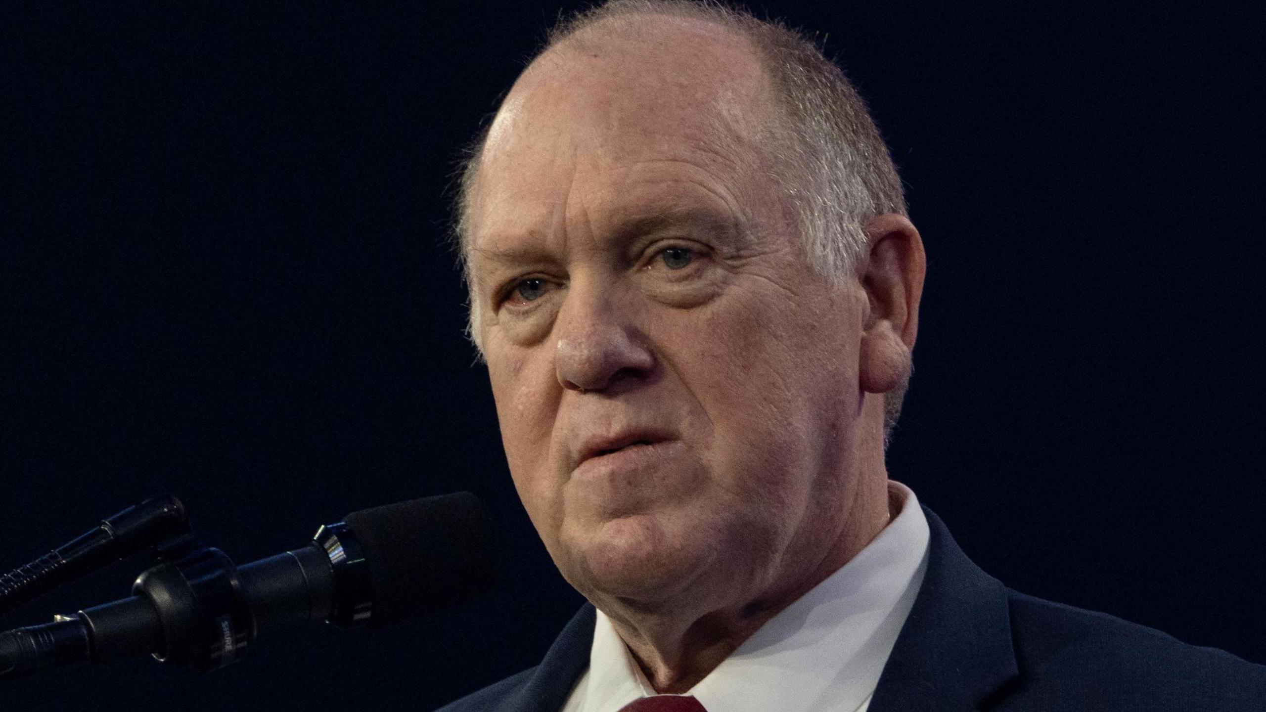 Tom Homan in a white shirt and black suit jacket during his speech at the AmericaFest 2024 conference sponsored by conservative group Turning Point USA in Phoenix, Arizona in December