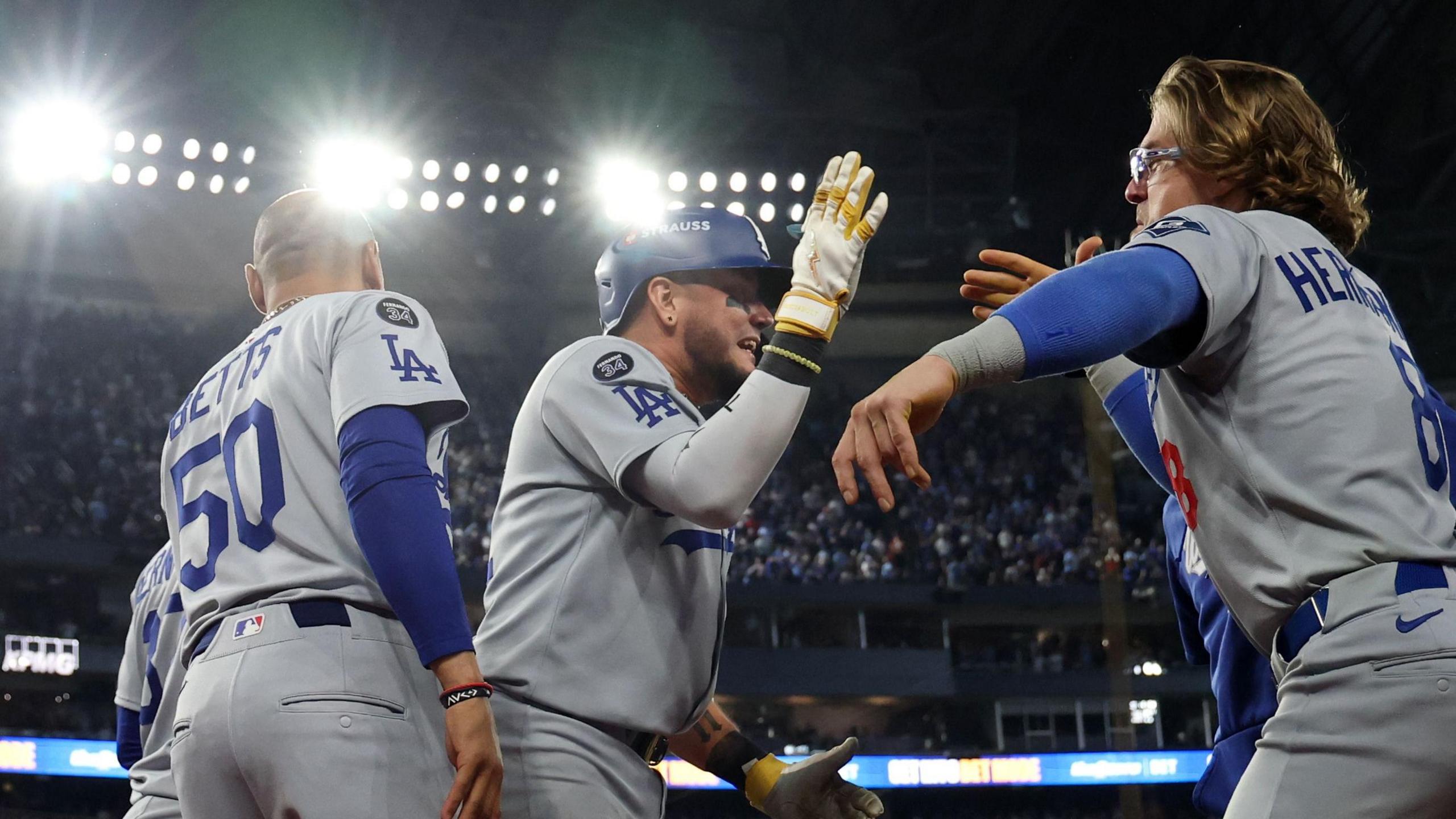 Los Angeles Dodgers batter Miguel Rojas (centre) is congratulated after his ninth-inning home run