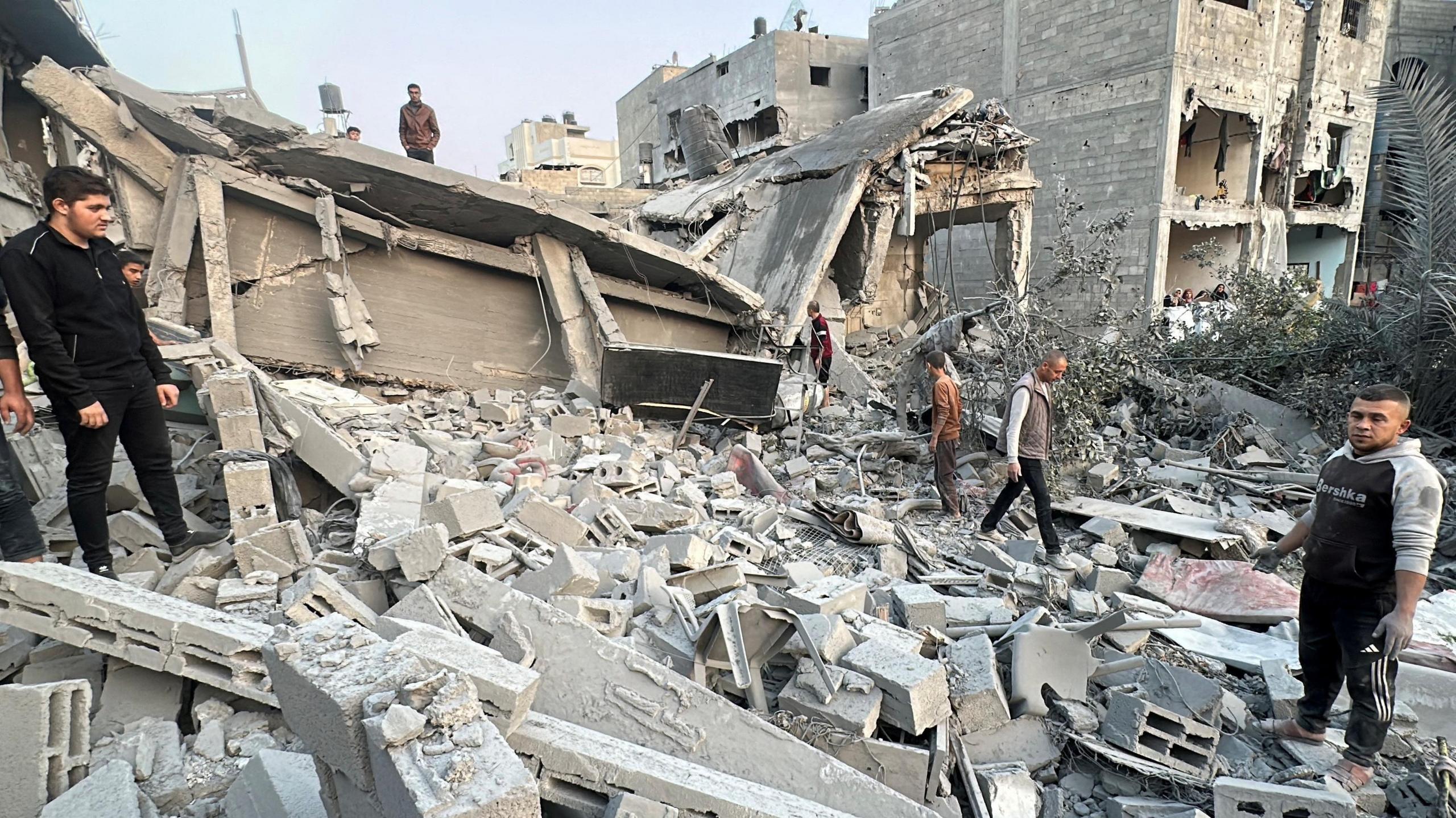 Palestinians gather at a pile of rubble at the site of an Israeli strike on a house, in Jabalia in the northern Gaza Strip