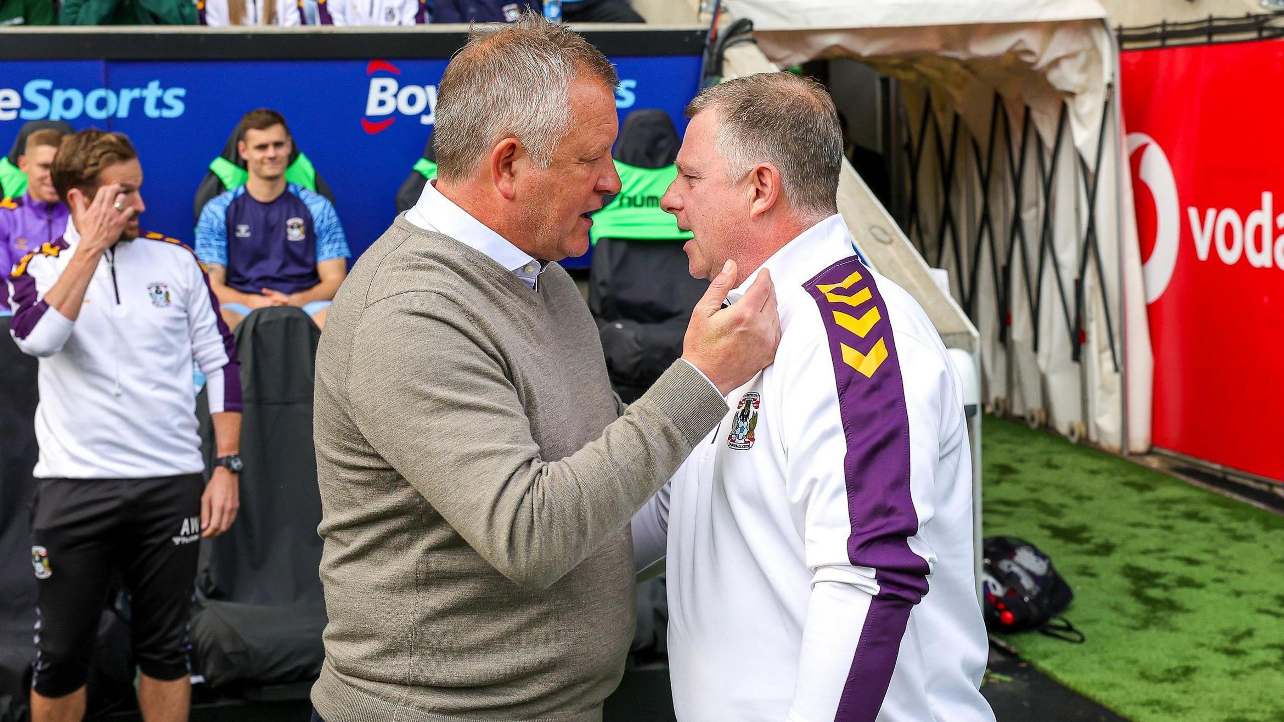 Chris Wilder and Mark Robins greeting each other on the touchline in 2022