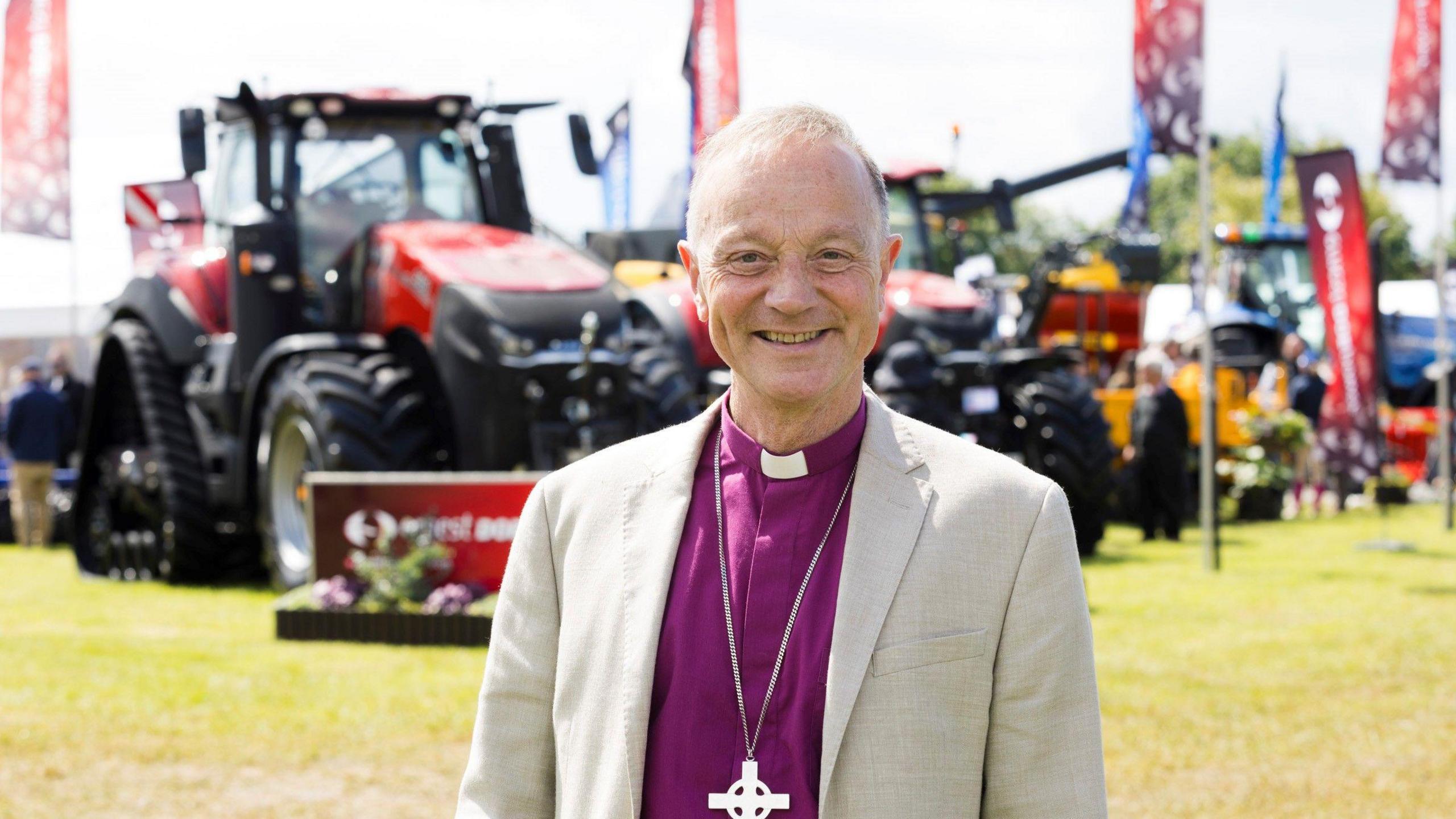 Rt Rev Dr Mike Harrison wearing Bishop's purple shirt with clerical white collar 