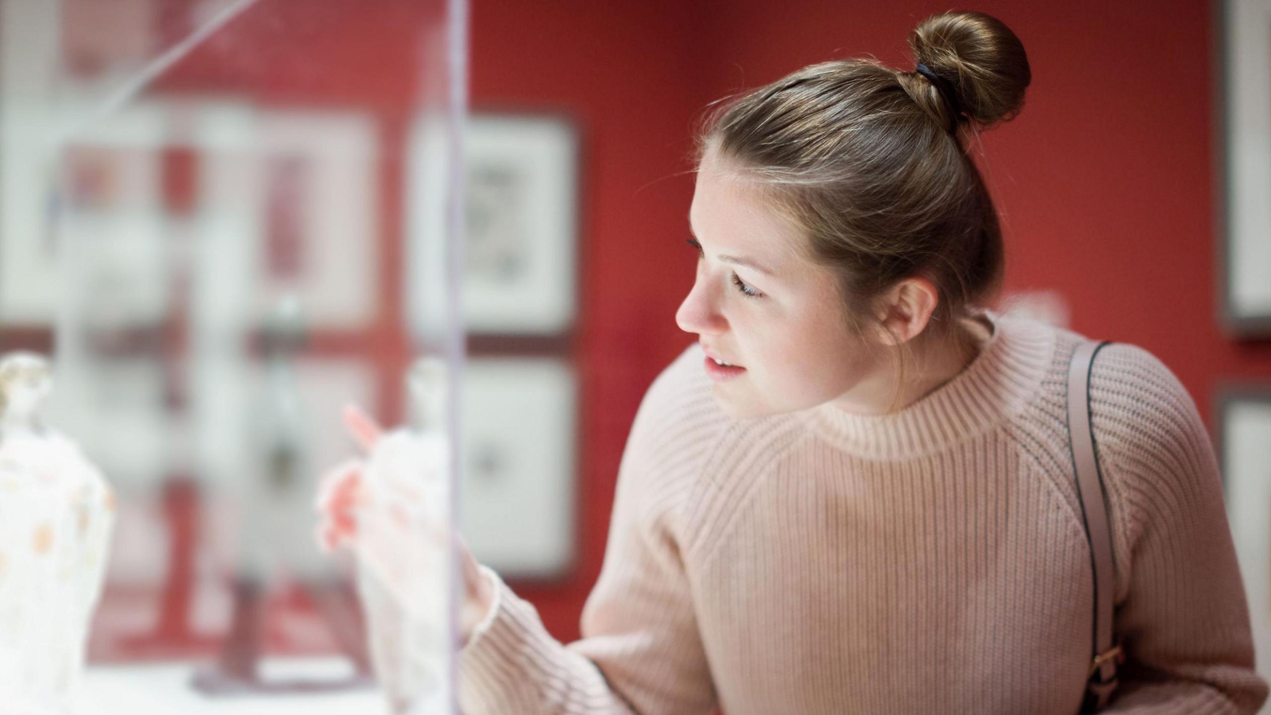 A woman looking at a cabinet display in a museum