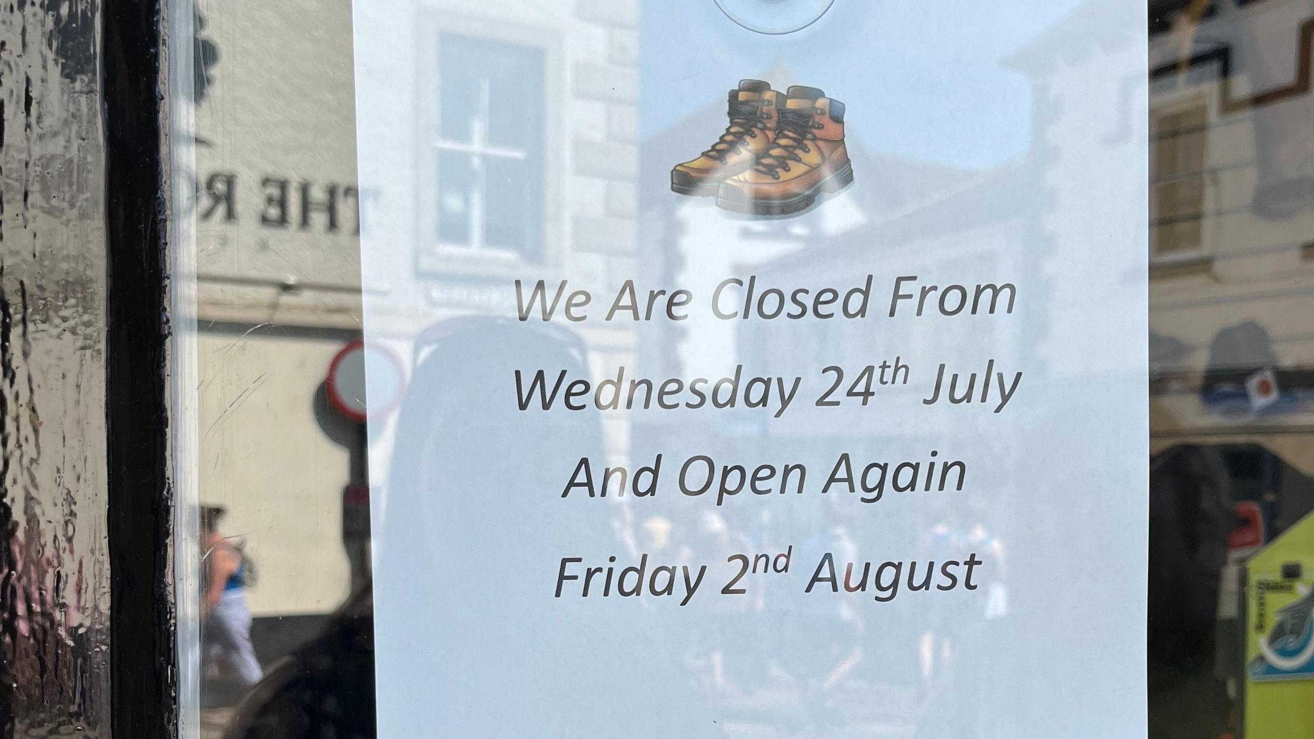 A notice on a shop window saying the business will be closed from 24 July to 2 August