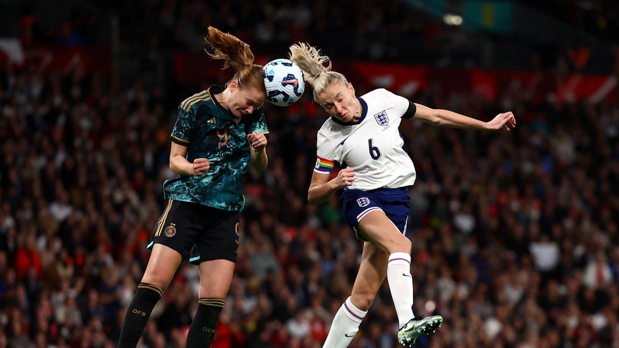 England's Leah Williamson and Germany's Sjoeke Nusken both heading a ball