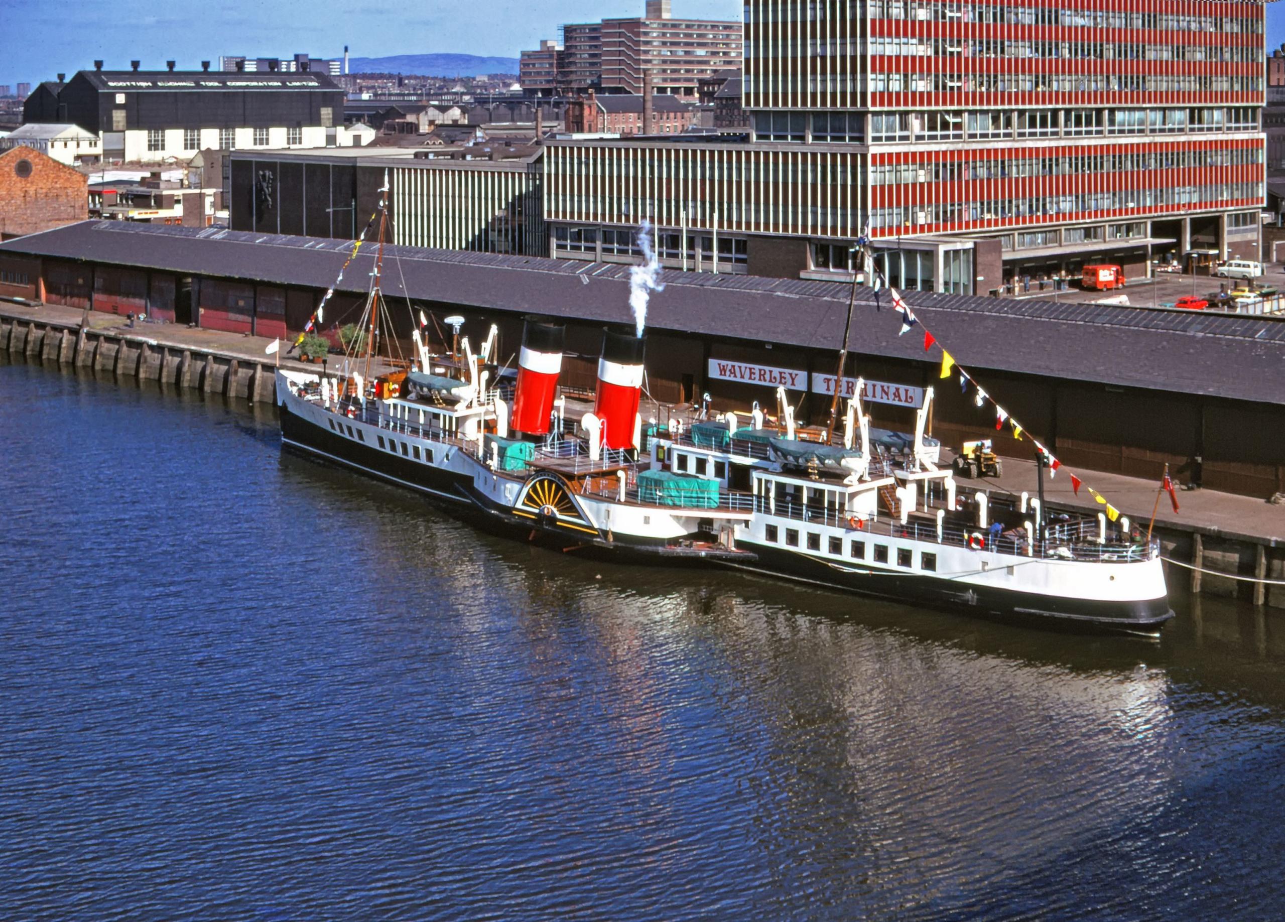 A wider shot of the Waverley at its terminal in Anderston Quay in the seventies. The former Daily Record building is in the background. And the ship is decked out in nautical flags.