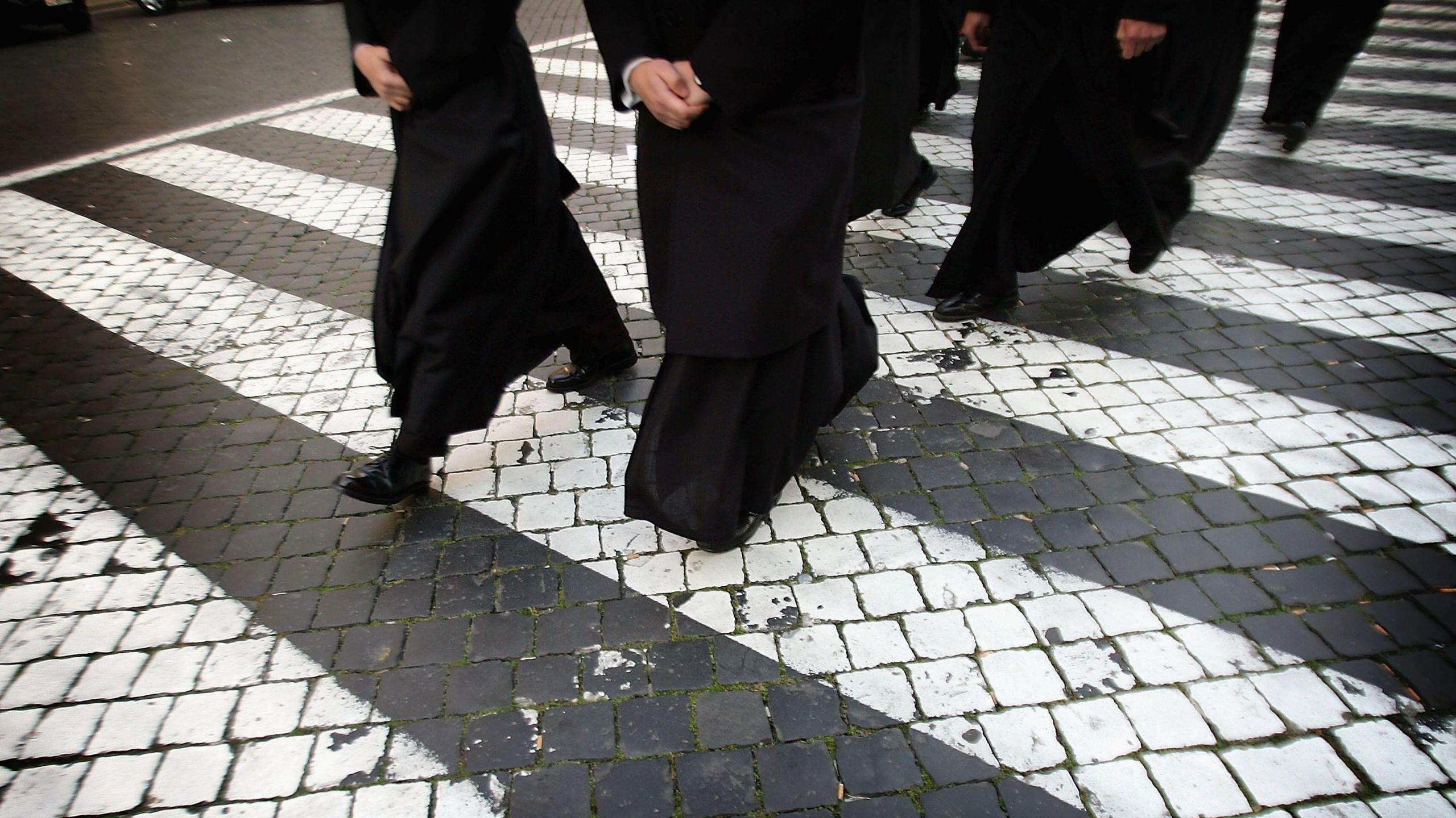 Priests make their way to wait in line to view the body of Pope John Paul II as it lays in state in the St Peter's Basilica April 5, 2005 in Vatican City