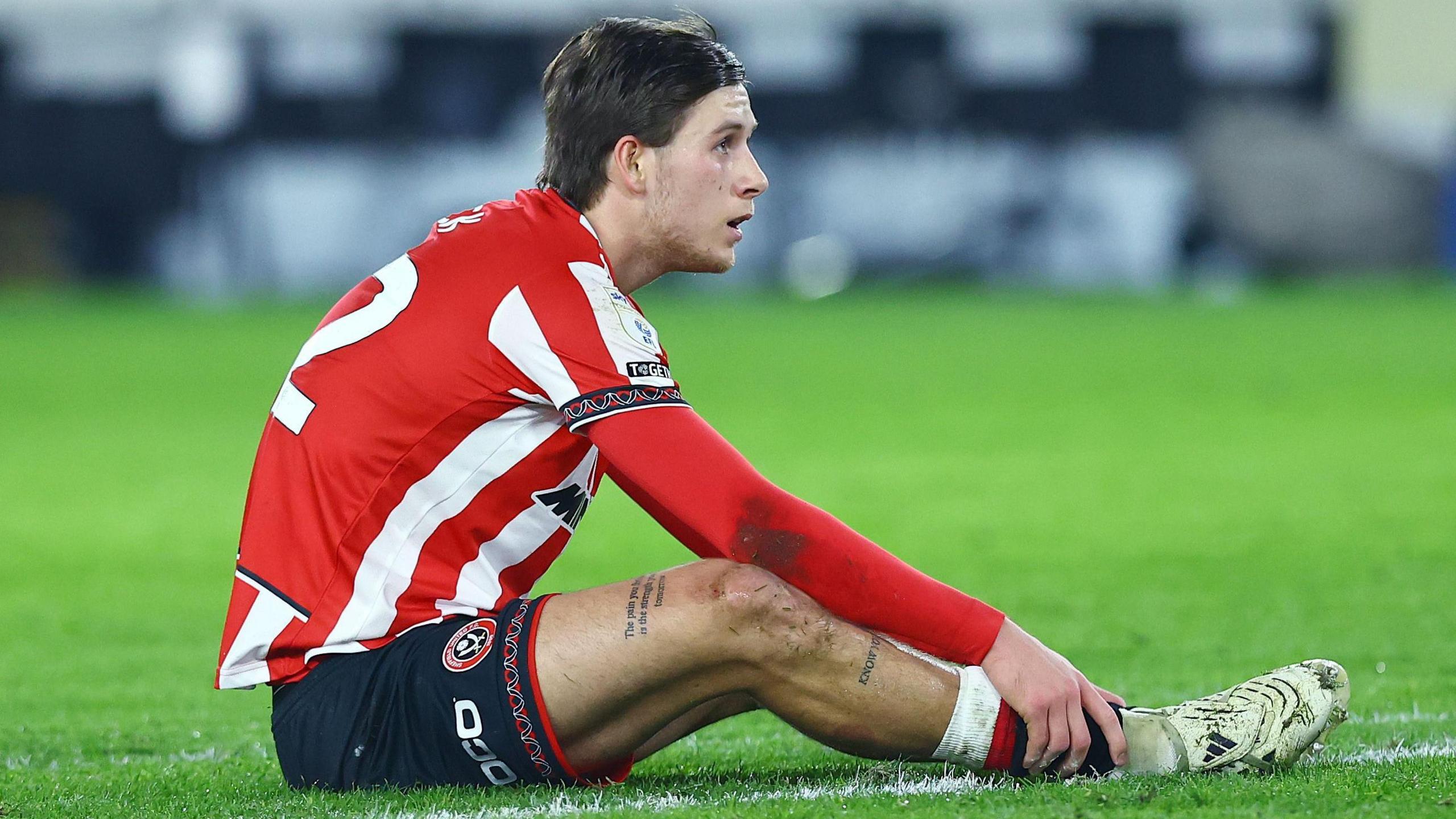 Sheffield United player Sydie Peck sits on the grass