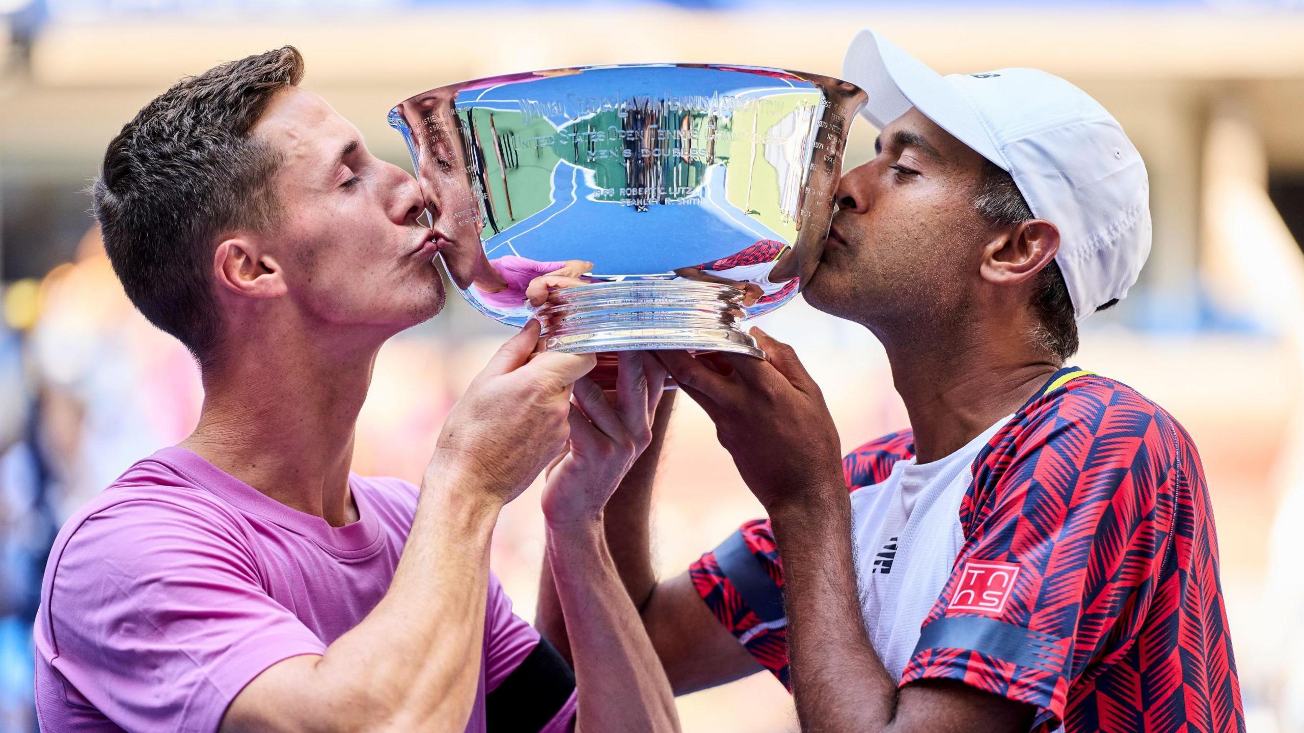 Joe Salisbury and Rajeev Ram kiss the US Open trophy after their title win in 2022