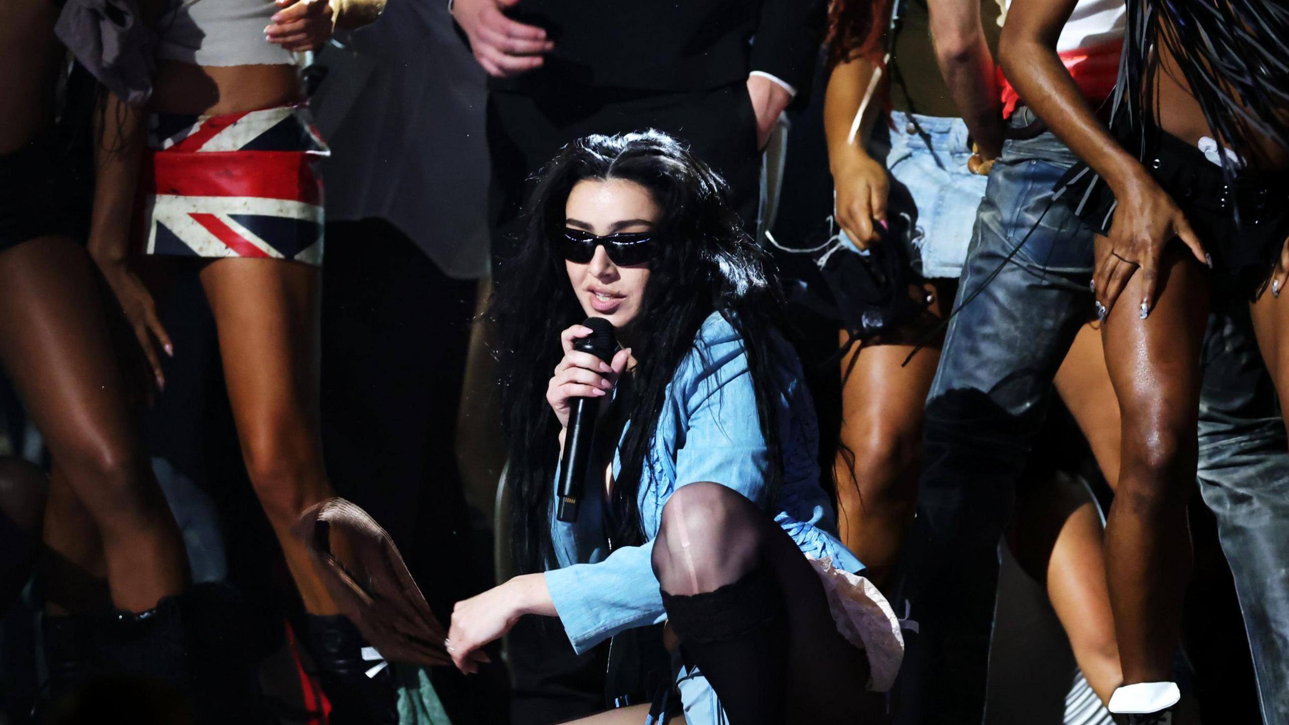 Charli XCX performing on stage with her dancers at the Grammys