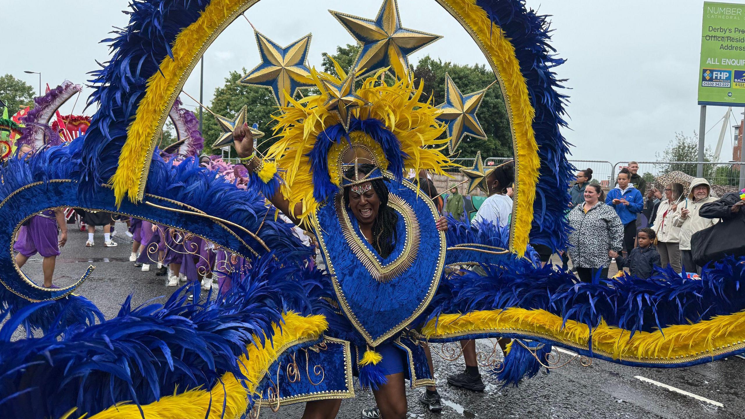 A woman in a huge blue outfit in front of onlookers