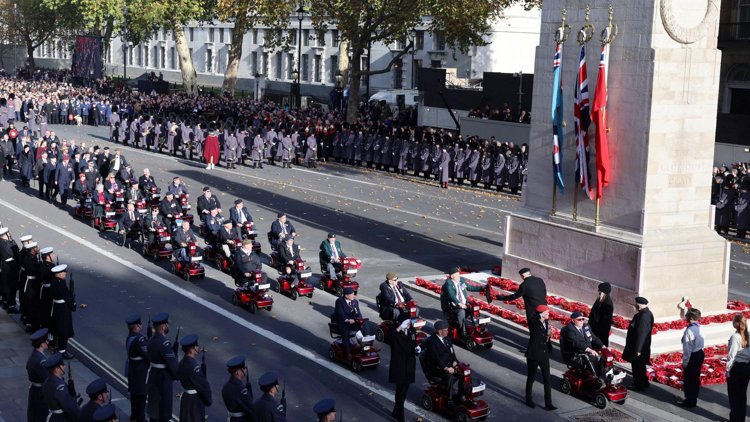 Veterans in mobility scootes going past the Cenotaph on Whitehall