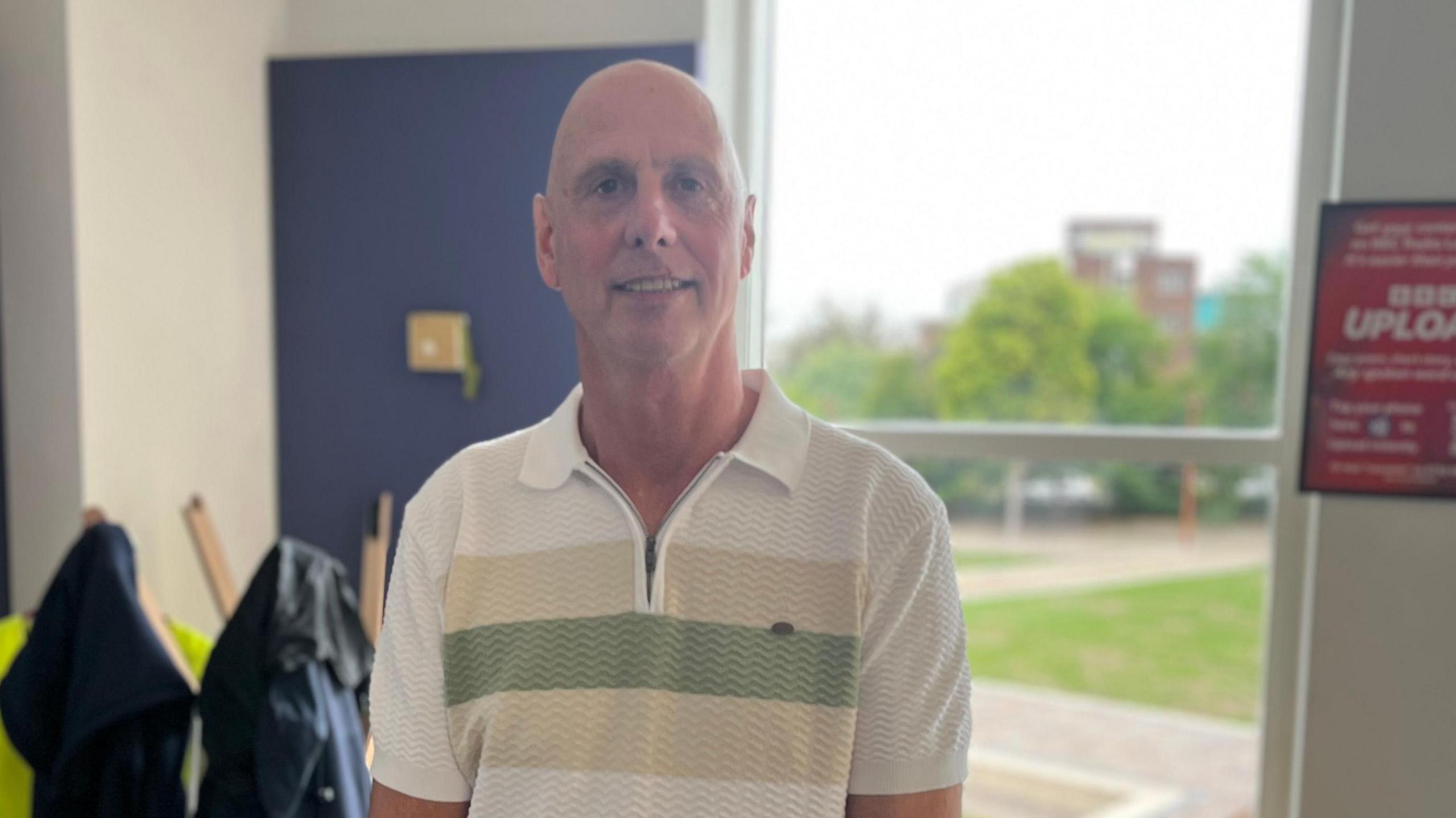 Jeff Boulton wearing a white polo shirt with green hoop.