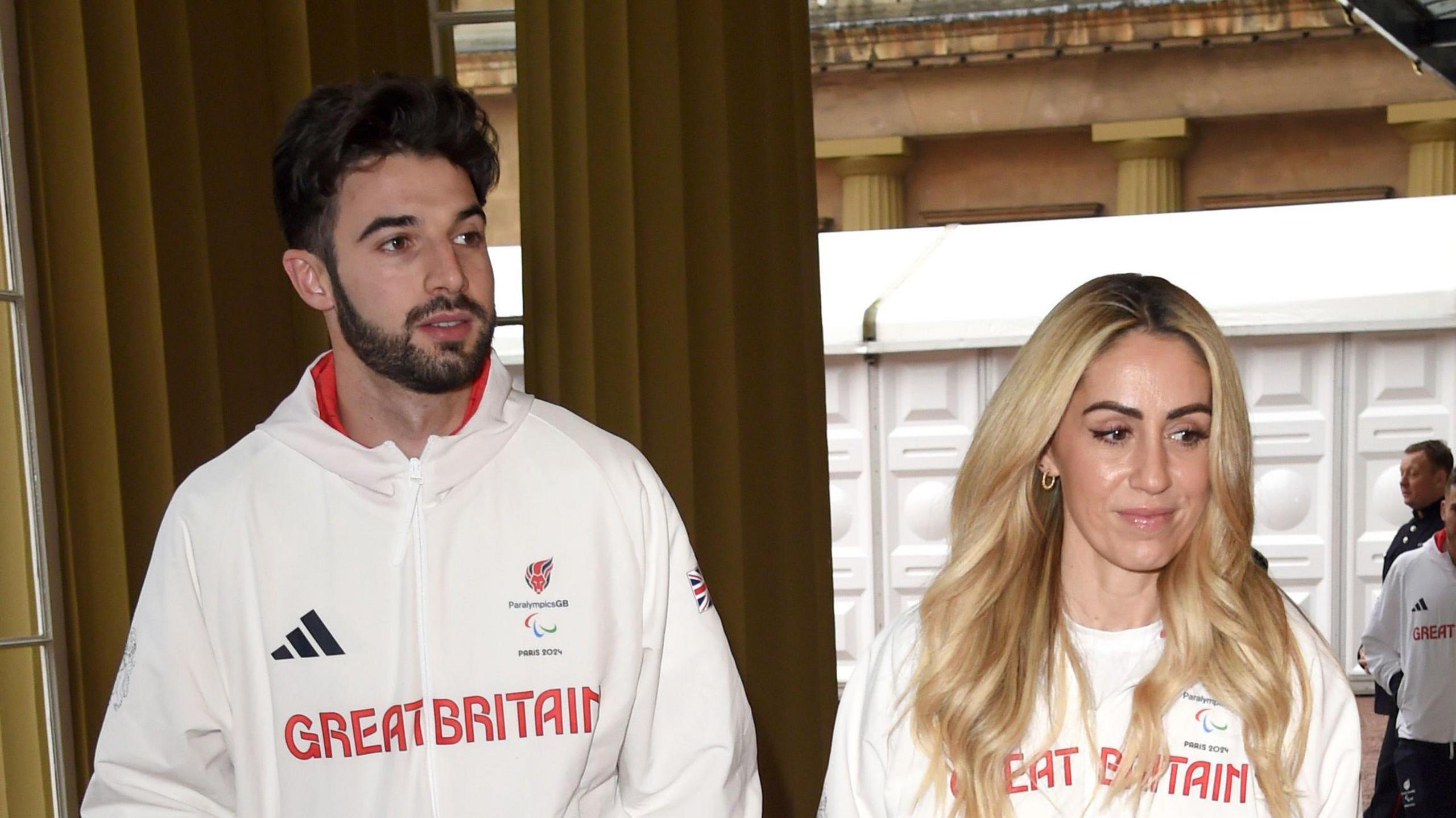 Zac Shaw and his partner Ali Smith, both wearing white Great Britain jumpers, attend a reception for medallists from the Paris 2024 Olympic and Paralympic Games at Buckingham Palace 