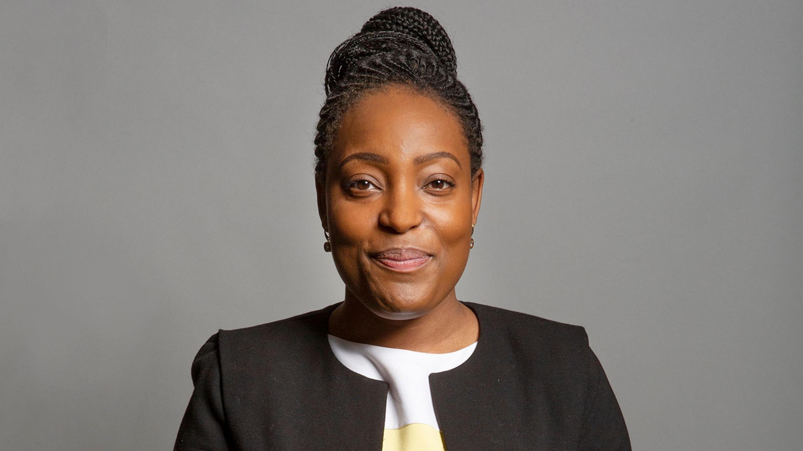 A portrait image of MP Taiwo Owatemi - her hair is tied up and she is wearing a white top and a black jacket.