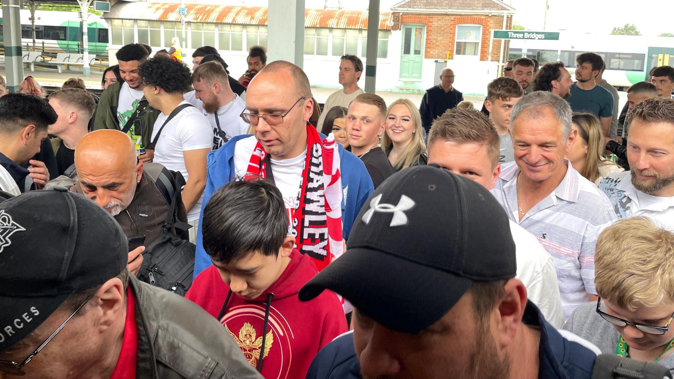 Crawley supporters waiting for a train at Three Bridges station