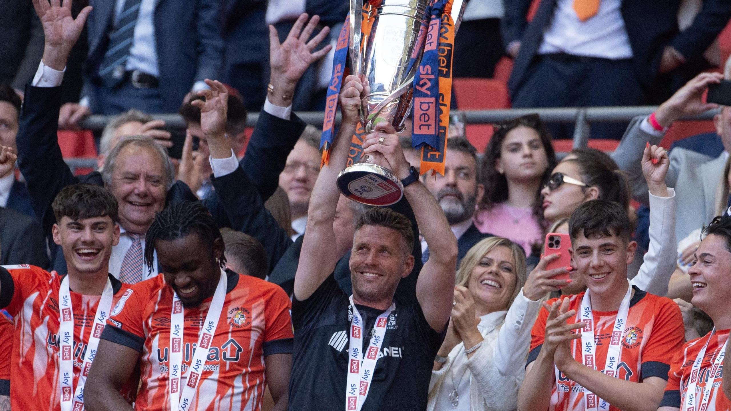 Rob Edwards lifts the play-off winners' trophy