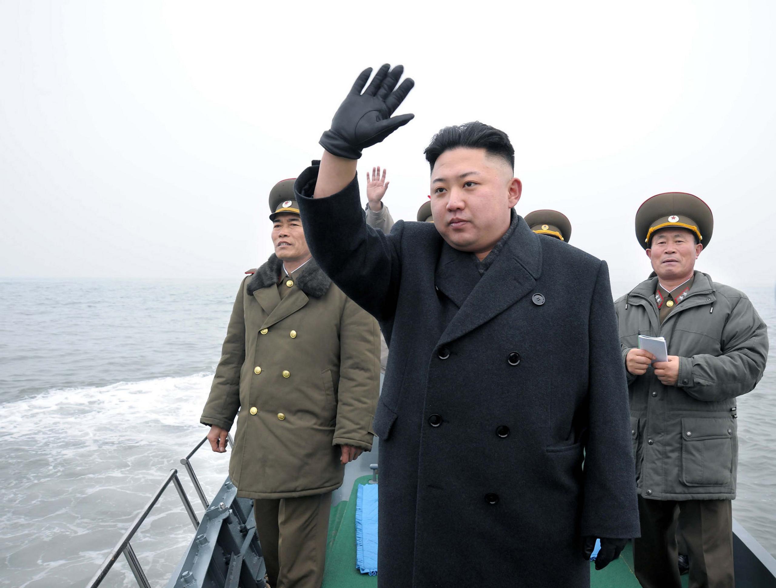 North Korean leader Kim Jong waves to soldiers from a wooden boat. 7 March 2013