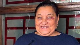 Astra Sirapina, 62, wearing a blue top in front of a wooden and glass door