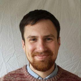 Head and shoulders picture of a smiling man with short, brown hair and well-trimmed brown beard.