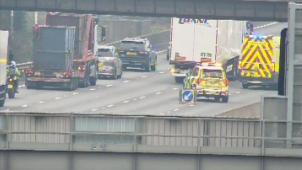 A road camera image of the M1 in Leicestershire, at junction 24, showing a number of emergency vehicles stopped in road with multiple lanes closed. 