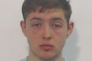 A mugshot of a young man with brown hair