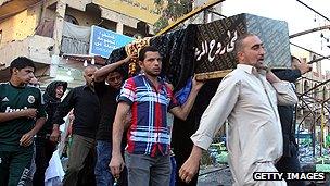 Coffin at the scene of a bombing in Baghdad