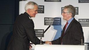 Tony Lloyd, Greater Manchester's PCC, shakes hands with chief constable Sir Peter Fahy