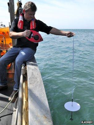 Skipper Alan Steer taking a secchi disk measurement (Image: Richard Kirby)