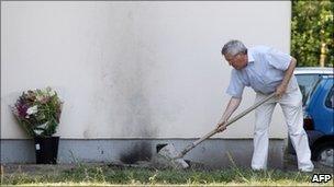 A man covers the traces of marks left by a French Telecom employee who set himself alight in a company carpark