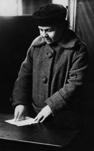 A woman casts her vote behind a screen at the constitutional assembly, during the Russian Revolution.