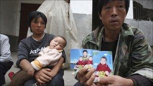 Li Xiaoquan and wife Li Aiqing with picture of twins, one of whom died from melamine-tainted milk, 2008