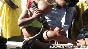 A young boy uses a phone provided by Telecoms Sans Frontieres