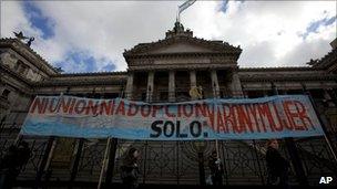 Demonstrators hold a banner that reads in Spanish "Neither union nor adoption. Only: men and women" outside Congress in Buenos Aires on 14 July