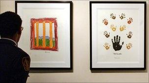 A man looks at some limited edition signed lithographs from former South African President Nelson Mandela on 9 March 2004 in New York City