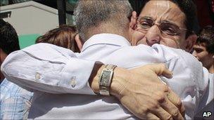 Cuban dissidents Normando Hernandez, right and Omar Rodriguez hug on arrival at a hostel in Madrid, on 14 July 2010