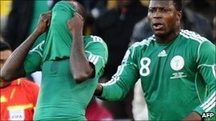 Nigeria's midfielder Sani Kaita (left) hides his face after being handed a red card