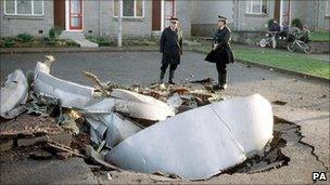 Police officers standing among debris in Lockerbie