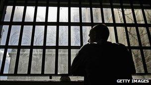 A young offender looking out of a window at an institution