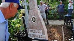 Romanians look at the tomb of Nicolae Ceausescu at the Ghencea cemetery in Bucharest, 21 July 2010